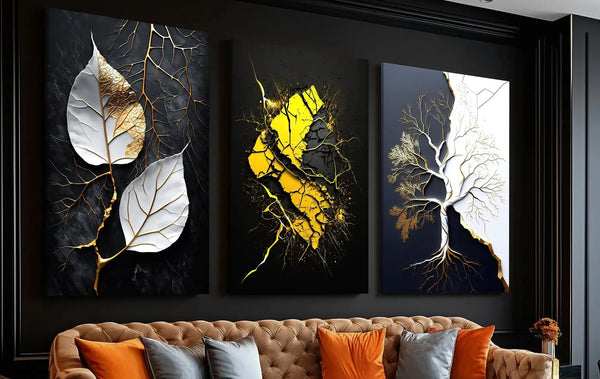 Three abstract wall art pieces on a dark wall above a sofa with colorful cushions.
