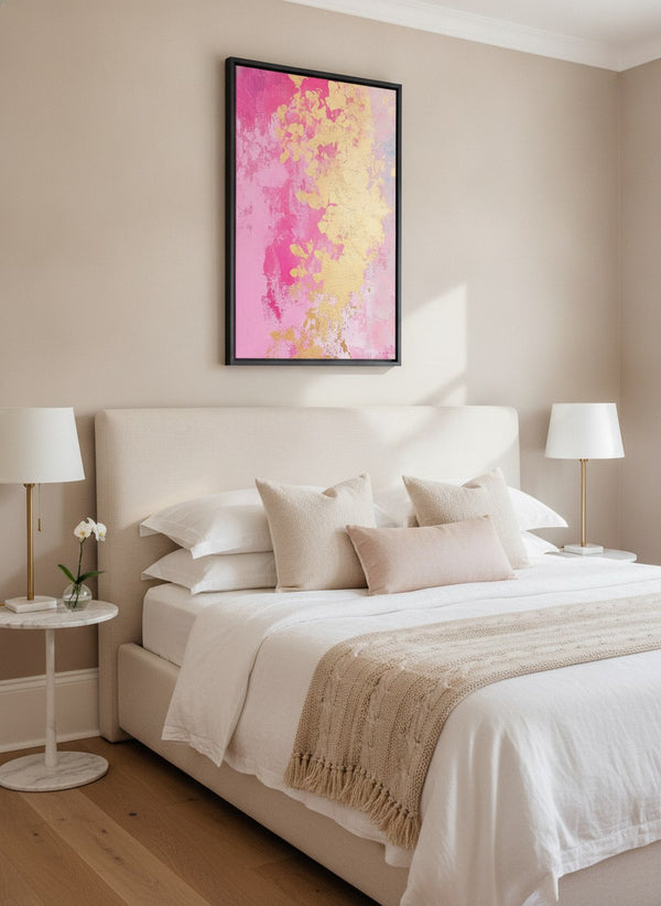 Golden Bloom pink and gold abstract canvas art in a black frame, hung above a bed in a bright beige bedroom | MusaArtGallery™