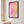 Pink and gold abstract canvas in a black frame in a light bedroom | MusaArtGallery