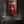 Red Buddha canvas art in a black frame, hung above a stone bathtub in a dark slate bathroom | MusaArtGallery™
